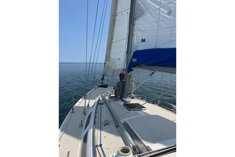 Slide: The Image of 1985 Catalina 36 sailboat on calm ocean waters under clear blue sky. - 4
