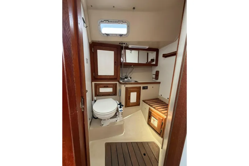 Slide: The Image of Interior of 1985 Catalina 36 sailboat bathroom with wooden cabinetry and compact design. - 43