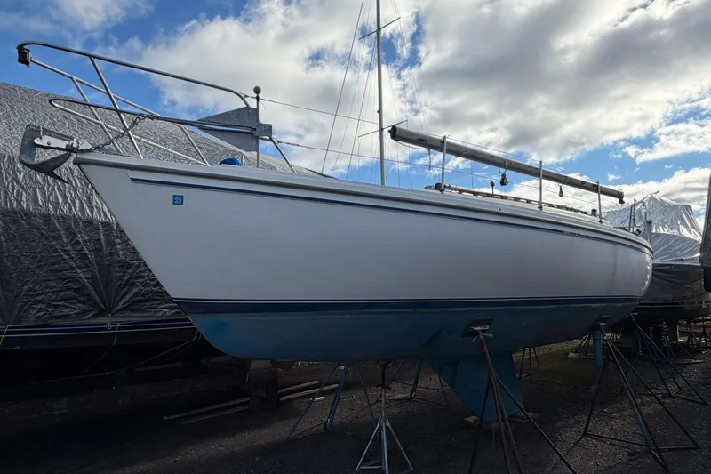 Slide: The Image of 1985 Catalina 36 sailboat on stands under a cloudy sky. - 47