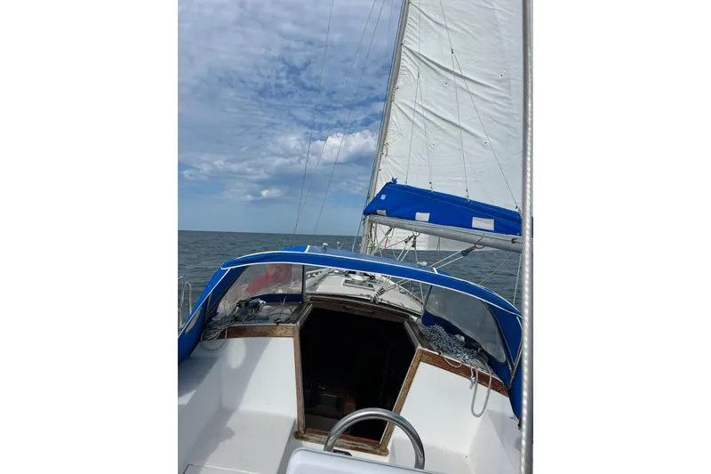 Slide: The Image of Sailing on a 1985 Catalina 36 yacht with blue and white sails under a cloudy sky. - 5