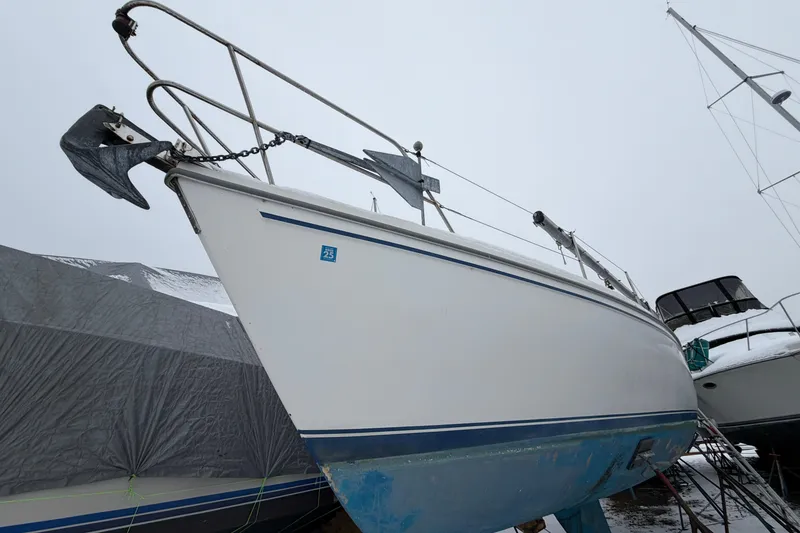 Slide: The Image of 1985 Catalina 36 sailboat on land, showing bow and anchor, under overcast sky. - 54