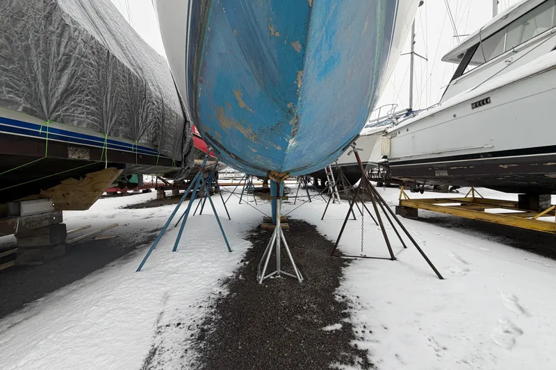 Slide: The Image of 1985 Catalina 36 sailboat on stands, surrounded by snow-covered ground. - 56