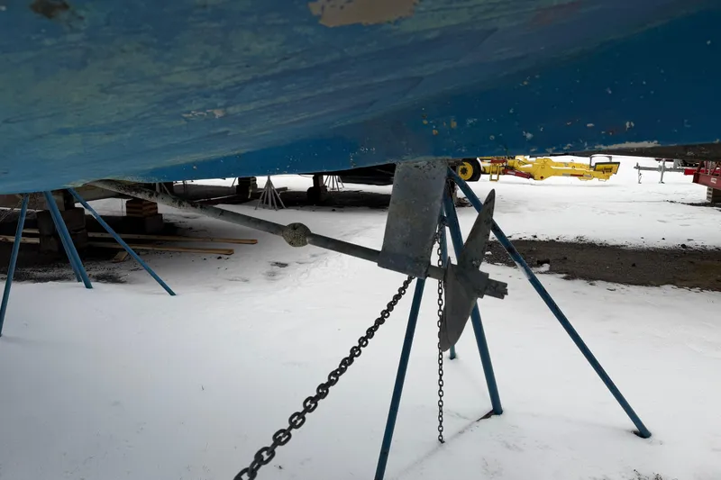 Slide: The Image of Catalina 36 sailboat from 1985 on stands, showing anchor and snowy ground. - 59