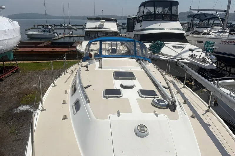 Slide: The Image of 1985 Catalina 36 sailboat docked at marina, surrounded by other boats. - 62