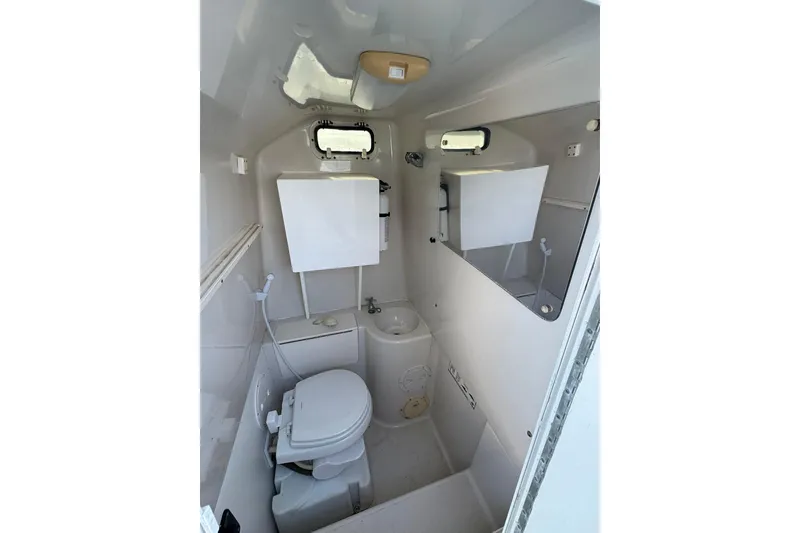 Slide: The Image of 1996 Pro-Line 3400 Cuddy boat bathroom with toilet, sink, and mirror. - 17