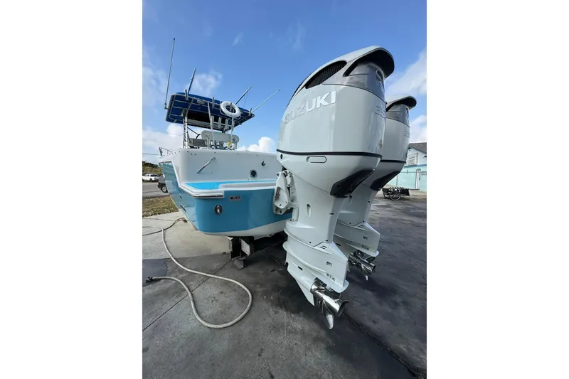 Slide: The Image of 1996 Pro-Line 3400 Cuddy boat with dual Suzuki outboard motors, docked on a sunny day. - 6