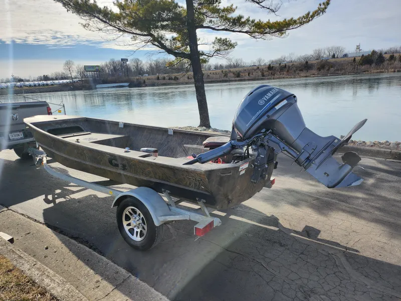 Slide: The Image of 2019 G3 Gator Tough 15 DK boat on trailer by a lakeside. - 1