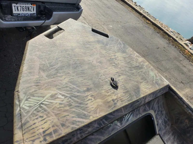 Slide: The Image of 2019 G3 Gator Tough 15 DK boat with camouflage pattern, parked near water. - 13
