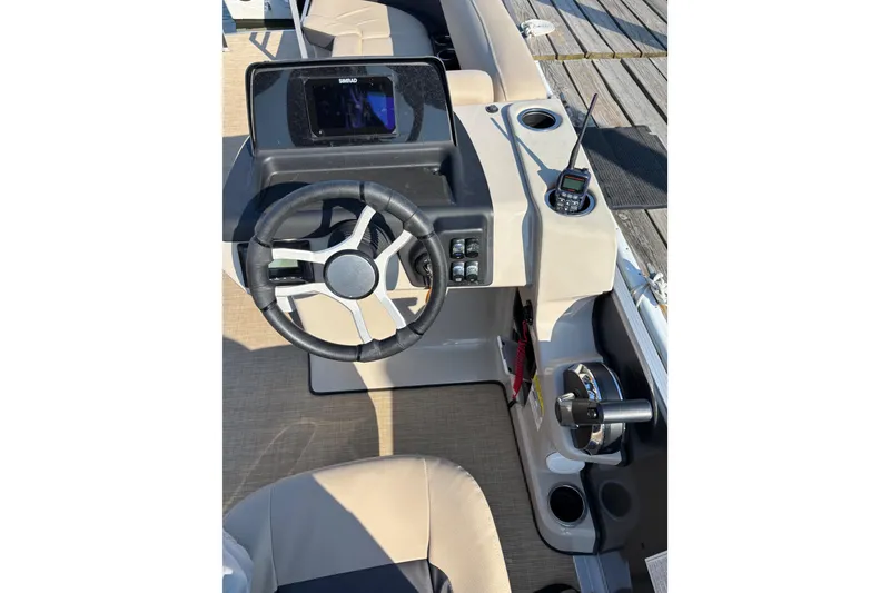 Slide: The Image of 2024 Harris HCX23 boat helm with steering wheel, control panel, and radio. - 4