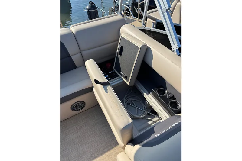 Slide: The Image of 2024 Harris HCX23 boat interior with open storage compartment and cup holders. - 5