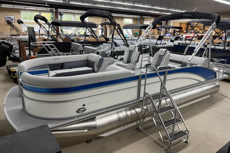 The Image of 2026 Harris Cruiser 230 pontoon boat in showroom, featuring sleek design and comfortable seating. - 1