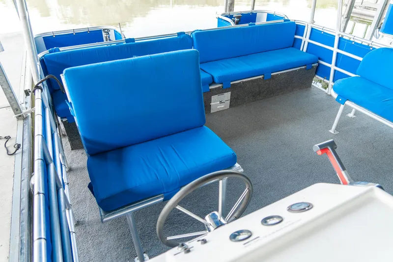 Slide: The Image of Interior of a 2000 Custom Pontoon Rental Fleet with blue seating and steering wheel. - 22