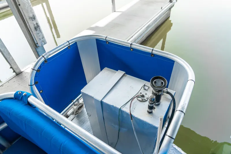 Slide: The Image of Pontoon boat control area with blue seating, docked by calm water. - 29