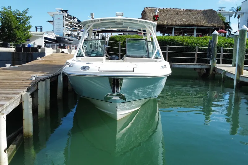 Slide: The Image of 2019 Boston Whaler 270 Vantage docked in a marina, clear water, sunny day. - 11