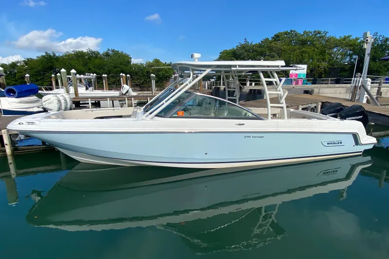 Slide: The Image of 2019 Boston Whaler 270 Vantage boat docked in a marina, clear blue sky. - 14