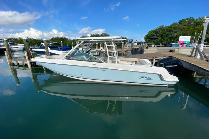 Slide: The Image of 2019 Boston Whaler 270 Vantage boat docked in calm marina waters. - 15