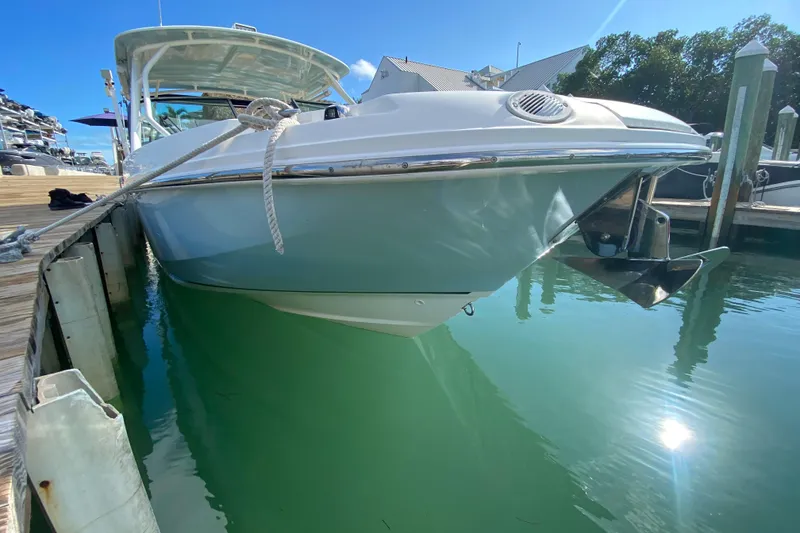 Slide: The Image of 2019 Boston Whaler 270 Vantage docked, reflecting on clear blue water. - 16