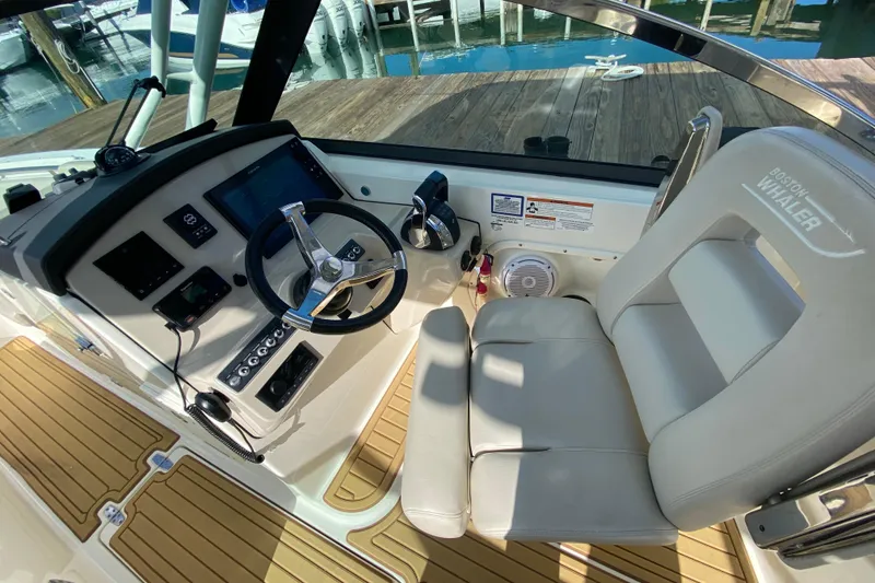 Slide: The Image of 2019 Boston Whaler 270 Vantage helm with steering wheel and control panel. - 20