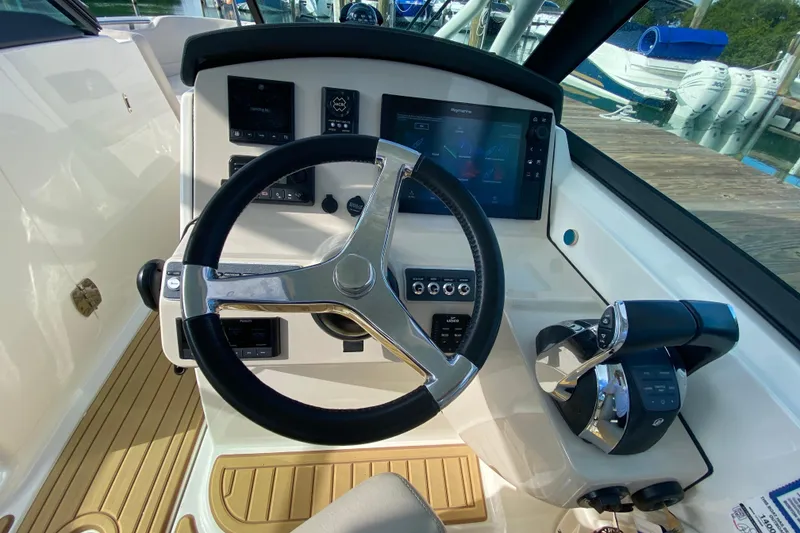 Slide: The Image of 2019 Boston Whaler 270 Vantage helm with steering wheel and control panel. - 24