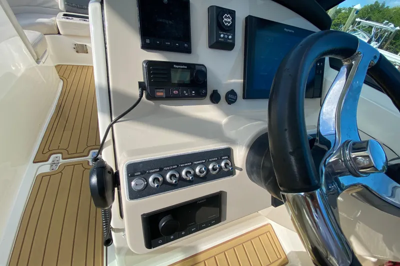 Slide: The Image of 2019 Boston Whaler 270 Vantage helm with steering wheel and control panel. - 25