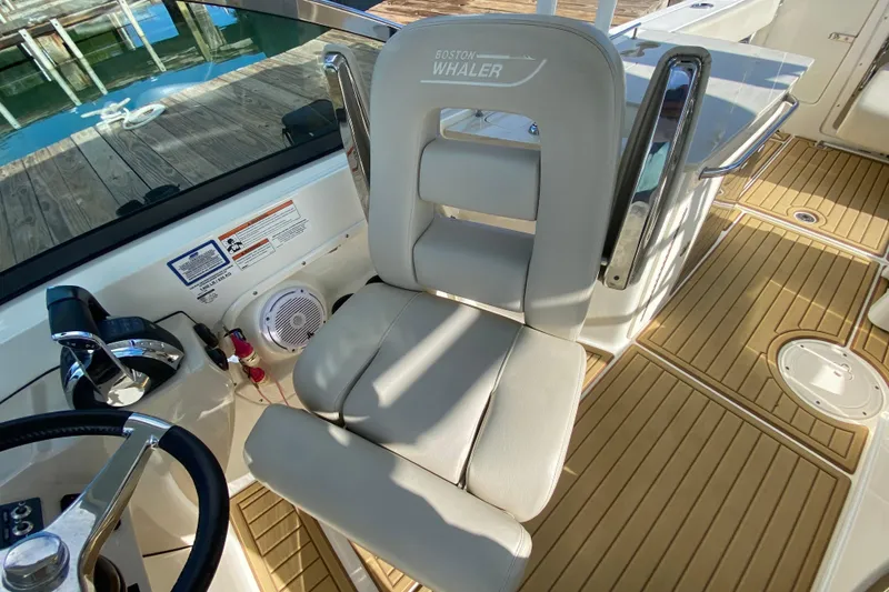 Slide: The Image of 2019 Boston Whaler 270 Vantage helm seat and controls, featuring teak flooring. - 27