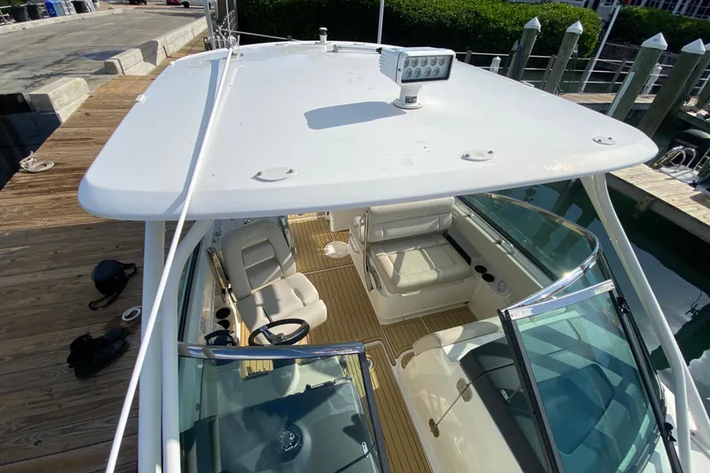 Slide: The Image of 2019 Boston Whaler 270 Vantage boat docked, showcasing seating and helm area. - 31
