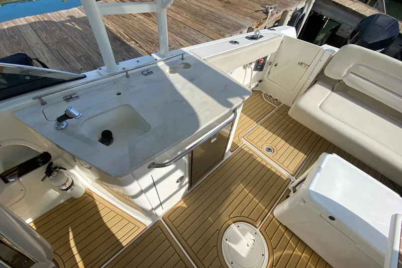 Slide: The Image of 2019 Boston Whaler 270 Vantage boat interior with sink, seating, and wooden deck. - 33