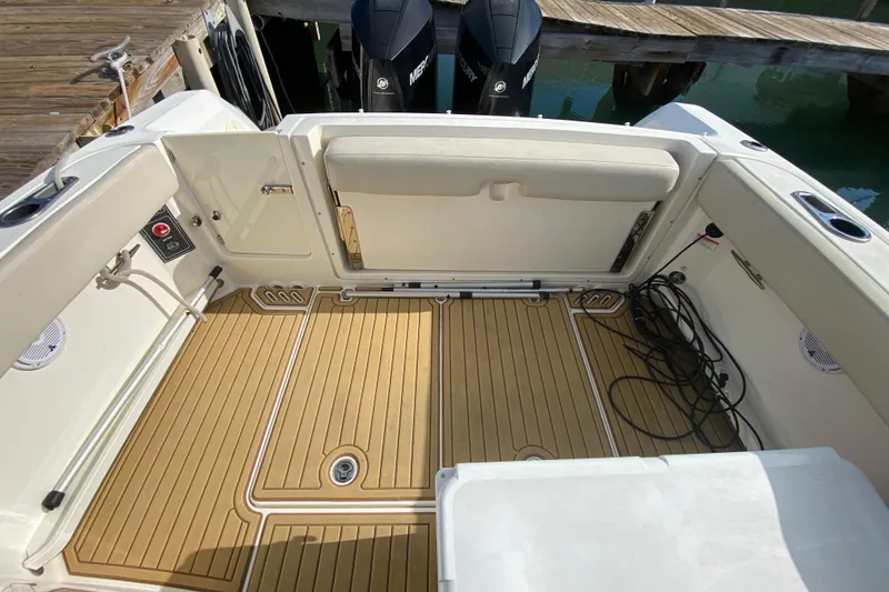 Slide: The Image of 2019 Boston Whaler 270 Vantage boat interior with teak flooring and dock view. - 36