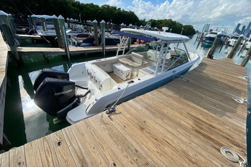 Slide: The Image of 2019 Boston Whaler 270 Vantage docked, featuring dual Mercury engines. - 58