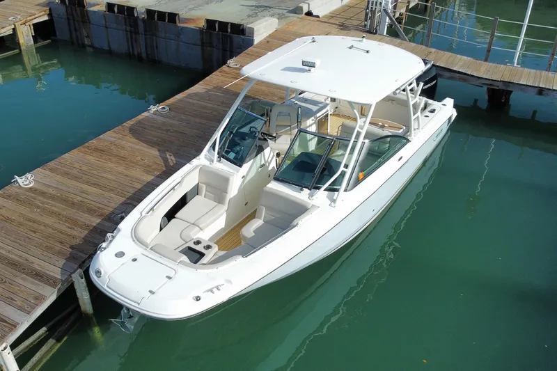 Slide: The Image of 2019 Boston Whaler 270 Vantage docked in clear water, showcasing sleek design and spacious seating. - 6