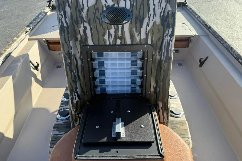 Slide: The Image of 2026 Avid 20 ROGUE CC boat with camo storage compartment and tackle boxes. - 16
