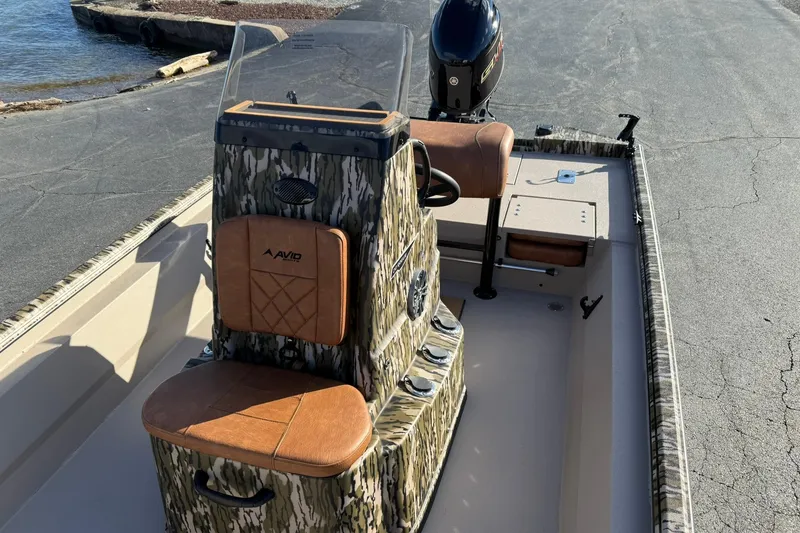 Slide: The Image of 2026 Avid 20 ROGUE CC boat with camo design and leather seating near water. - 18