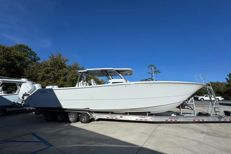 Slide: The Image of 2026 Invincible 46 Catamaran on trailer, parked outdoors under clear blue sky. - 11