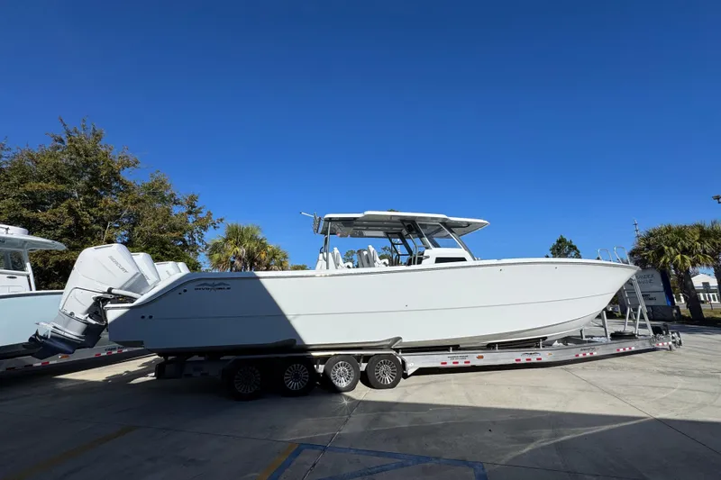 Slide: The Image of 2026 Invincible 46 Catamaran on trailer, parked outdoors under clear blue sky. - 12