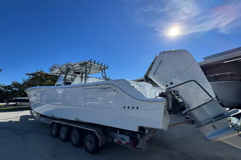 Slide: The Image of 2026 Invincible 46 Catamaran with Mercury engines on a trailer under a clear blue sky. - 17