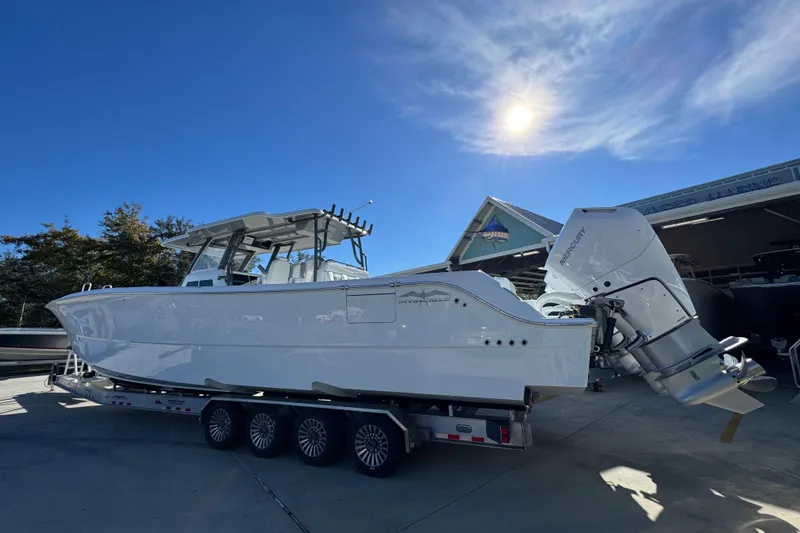 Slide: The Image of 2026 Invincible 46 Catamaran on trailer under clear blue sky. - 18