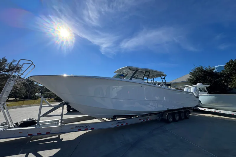 Slide: The Image of 2026 Invincible 46 Catamaran on trailer under bright sunlit sky. - 2