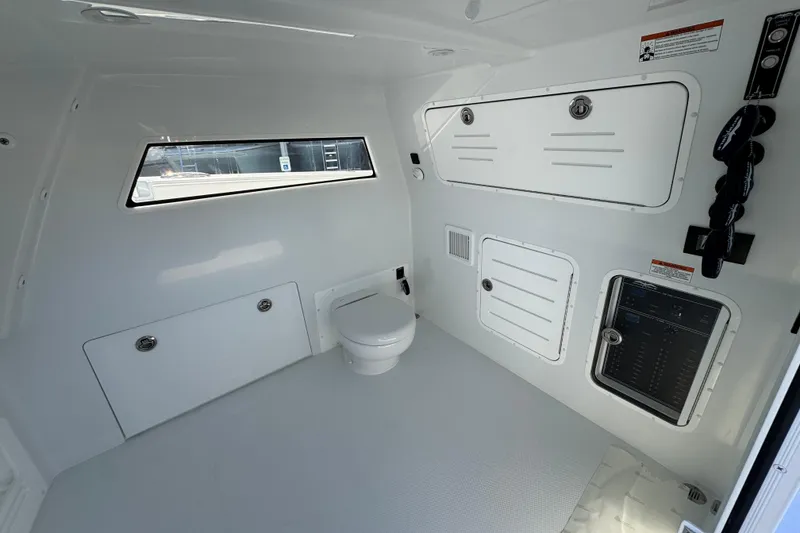 Slide: The Image of Interior of 2026 Invincible 46 Catamaran featuring a modern marine toilet and control panel. - 29