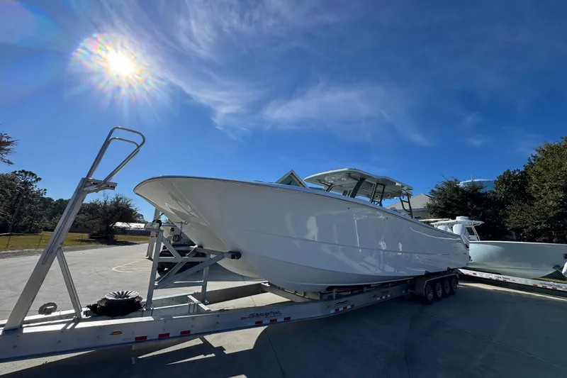 Slide: The Image of 2026 Invincible 46 Catamaran on trailer under bright sun, clear blue sky. - 3
