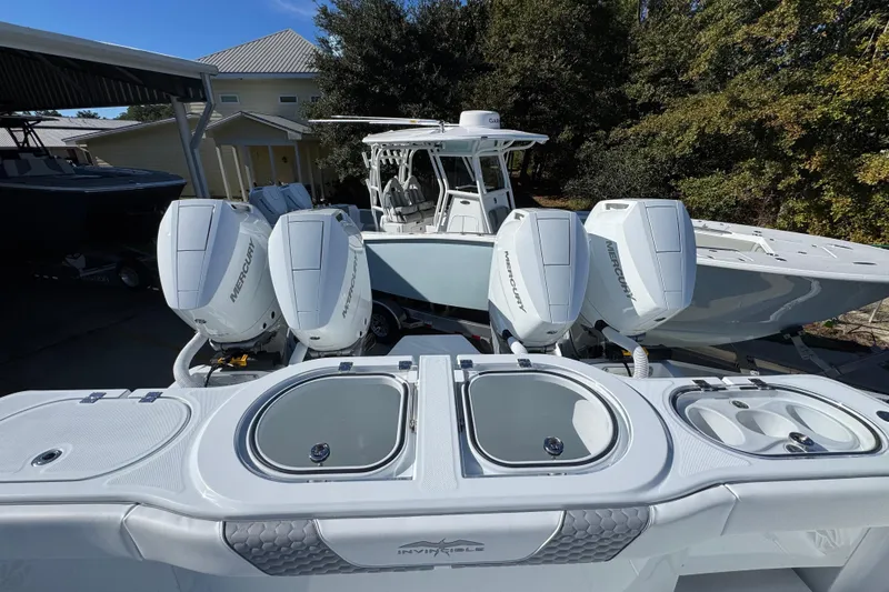 Slide: The Image of 2026 Invincible 46 Catamaran with four Mercury outboard engines, docked outdoors. - 48