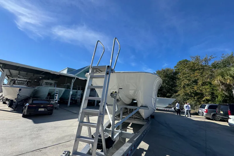 Slide: The Image of 2026 Invincible 46 Catamaran on trailer, surrounded by cars and trees under clear blue sky. - 5