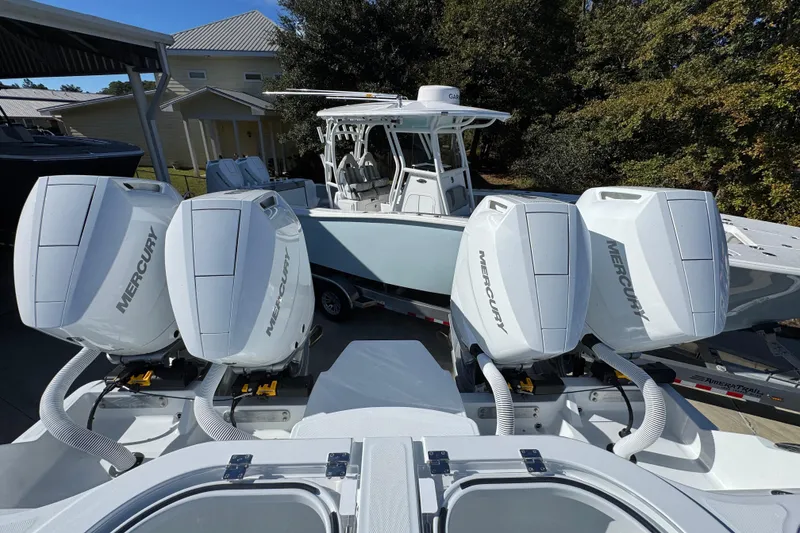 Slide: The Image of 2026 Invincible 46 Catamaran with four Mercury outboard engines, docked outdoors. - 51