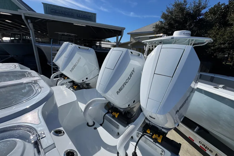 Slide: The Image of Triple Mercury outboard engines on a 2026 Invincible 46 Catamaran at a marina. - 52
