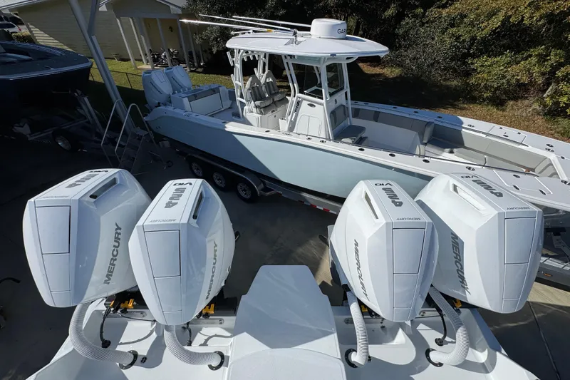 Slide: The Image of 2026 Invincible 46 Catamaran with four Mercury outboard engines, docked outdoors. - 54