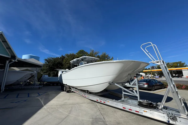 Slide: The Image of 2026 Invincible 46 Catamaran on trailer under clear blue sky. - 8