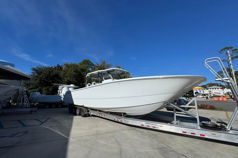 Slide: The Image of 2026 Invincible 46 Catamaran on trailer under clear blue sky. - 9