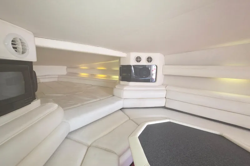 Slide: The Image of Interior of a 1992 Fountain boat cabin with white seating and built-in speakers. - 25
