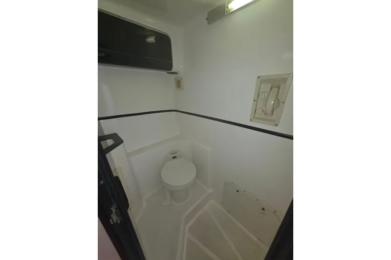 Slide: The Image of 1992 Fountain boat bathroom interior with toilet and storage compartments. - 28