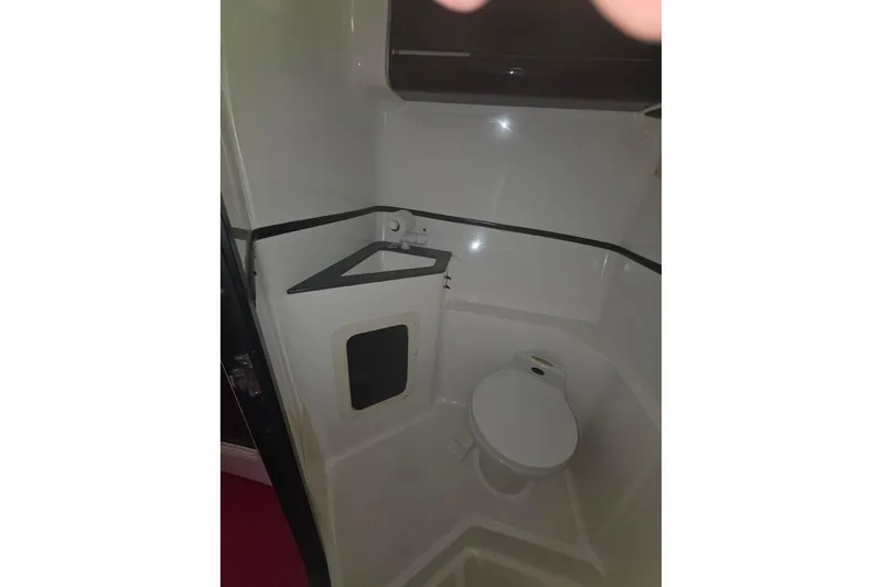 Slide: The Image of Compact bathroom in a 1992 Fountain boat, featuring a toilet and storage area. - 29