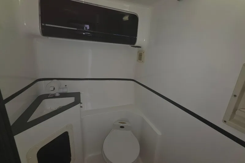 Slide: The Image of 1992 Fountain boat bathroom with toilet and sink, featuring sleek white interior design. - 30